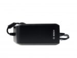 Main rangeant un chargeur Bosch 6A dans une sacoche de vélo.